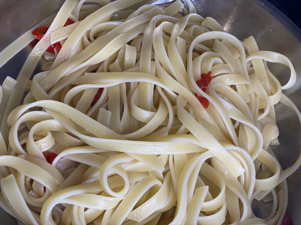 Fettuccine mit Chili, Knoblauch, Butter in Pfanne