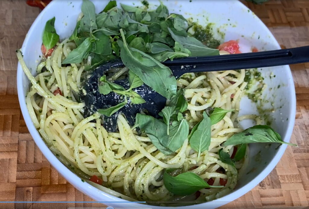 Schüssel mit gekochten Spaghetti und frischem Basilikum