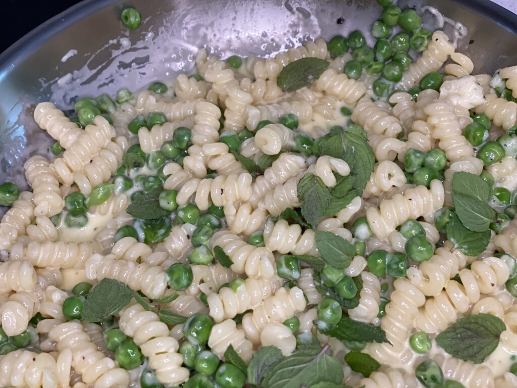 Fusilli mit Erbsen, Sauce und Minze in Pfanne