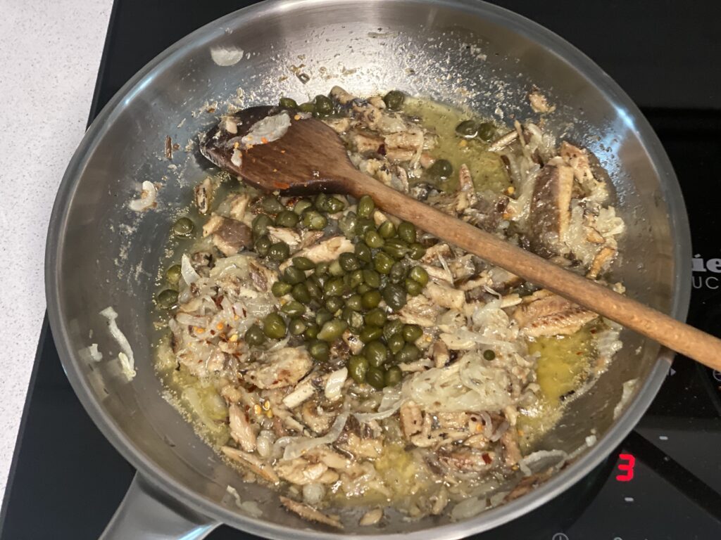 Pfanne mit Sardinen-Zwiebelsauce, Chili und Kapern