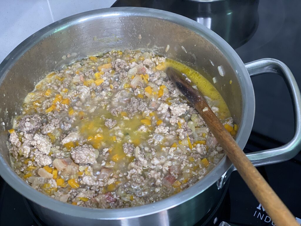 Topf mit Hackfleisch und Gemüse in Brühe