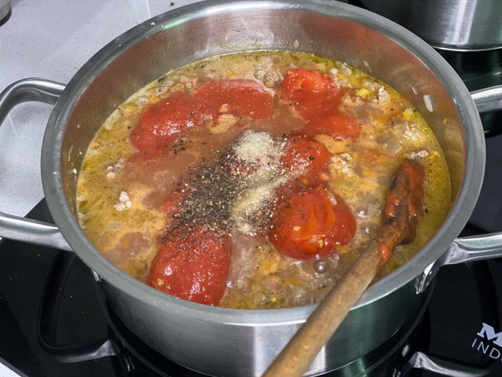 Topf mit Fleischsoße und Tomaten