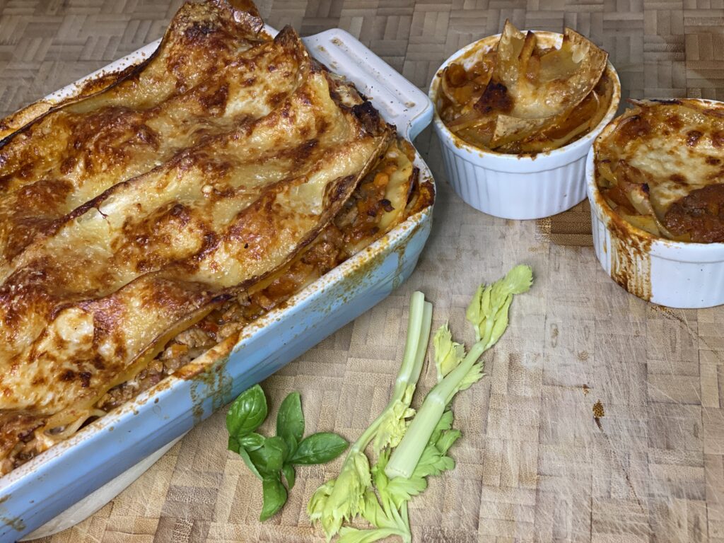 Eine große und zwei kleine Auflaufformen mit Lasagne