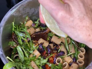 Topf mit Rigatoni und Sugo wird mit Zitrone abgeschmeckt