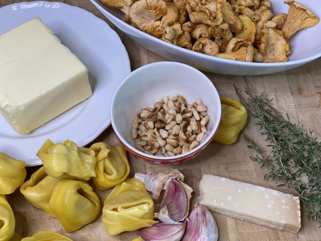 Butter, Pfifferlingen, Tortelloni, Pinienkerne und Parmesan
